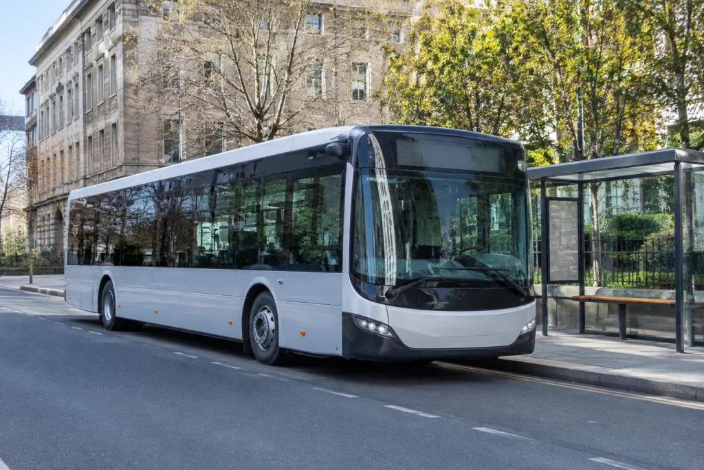Unbranded city bus standing beside a glass bus shelter